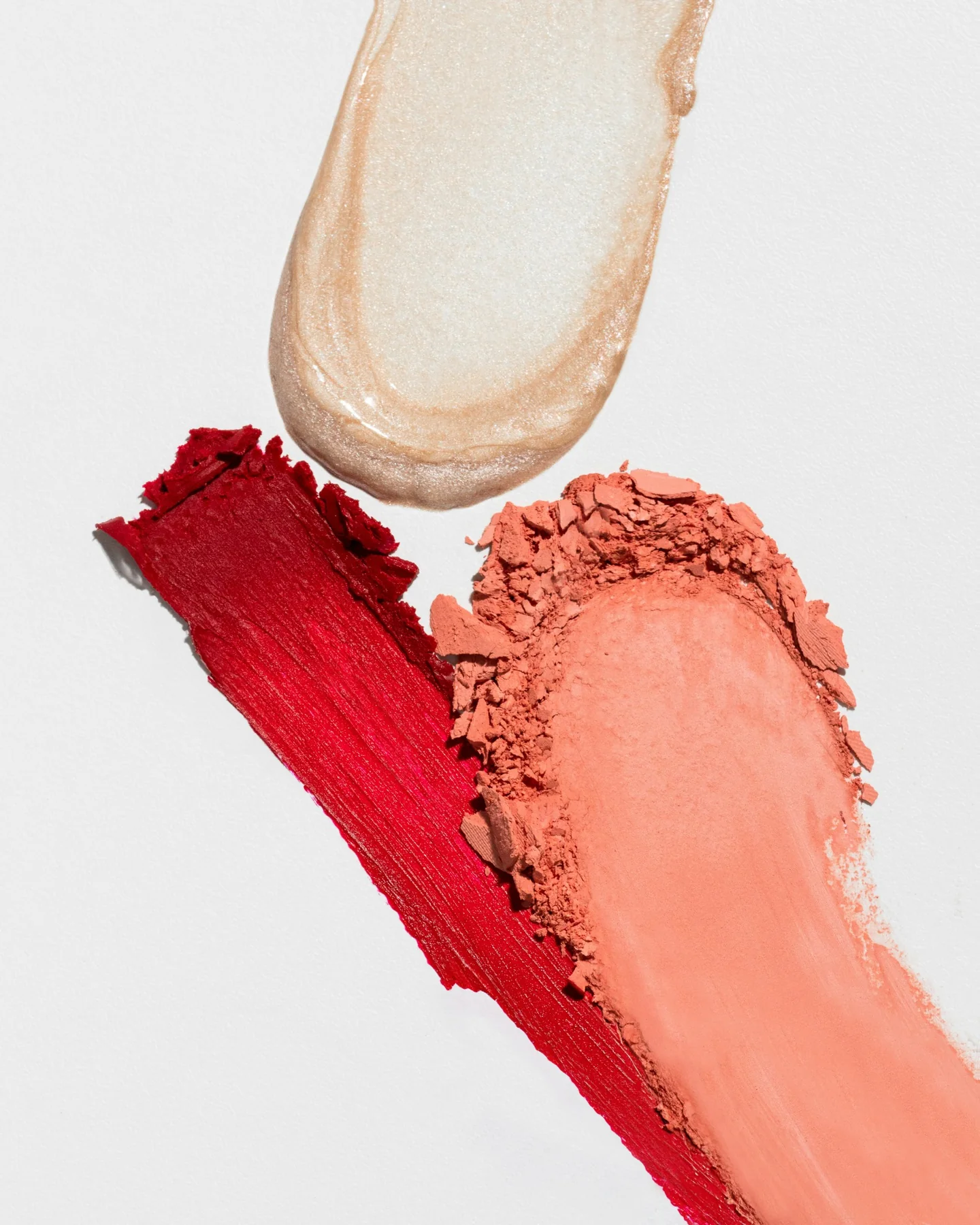 Cosmetic texture swatches in red, peach and shimmer